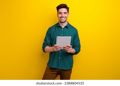 Photo of nice responsible successful man dressed trendy clothes use modern gadget ipad tablet isolated on yellow color background - Powered by Shutterstock