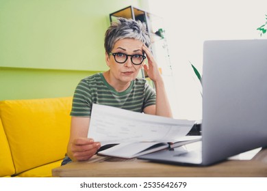 Photo of nice retired female stressed remote worker papers trouble wear green clothes enjoy cozy interior flat indoors - Powered by Shutterstock