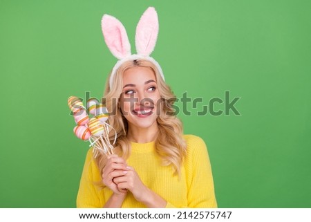Photo of nice young blond lady hold eggs look promo wear ears yellow pullover isolated on green color background