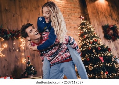 Photo of nice young couple playful piggyback cuddle wear christmas clothes enjoy cozy x-mas party decoration interior flat indoors - Powered by Shutterstock