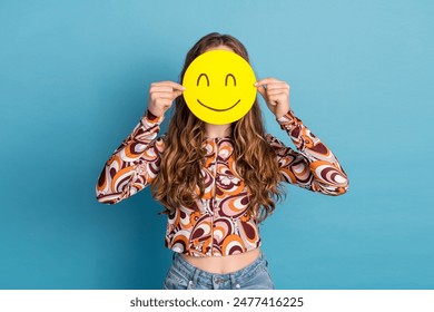 Photo of nice young girl emoticon cover face wear top isolated on blue color background - Powered by Shutterstock