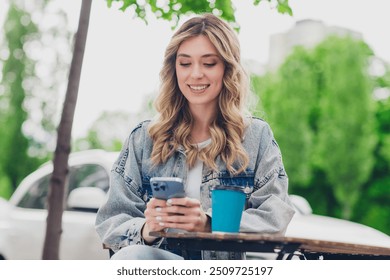 Photo of nice young woman use smart phone wear denim jacket walk city center cafe outdoors