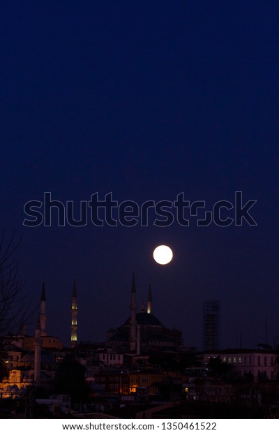 Photo of night city and\
round moon
