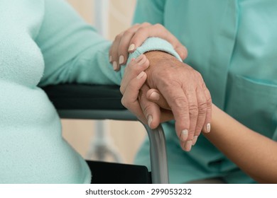 Photo of nurse supporting old woman on wheelchair - Shutterstock ID 299053232