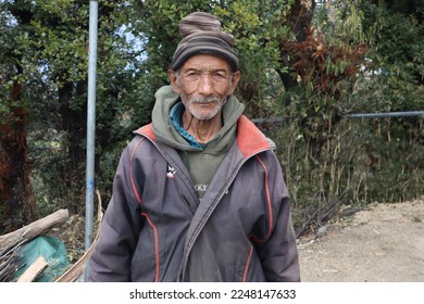 Photo Off an Indian old man outside his rural home while posing for a photo