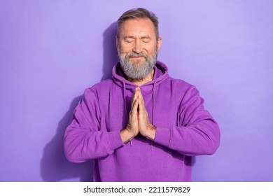 Photo of old handsome positive optimistic man dressed purple hoodie arms together praying eyes closed isolated on violet color background - Powered by Shutterstock