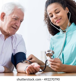 Photo Of Old Male And Nurse Taking Blood Pressure