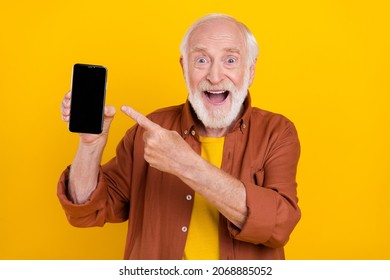 Photo Of Old Man Hold Phone Empty Space Direct Finger Touchscreen Wear Brown Shirt Isolated Yellow Color Background