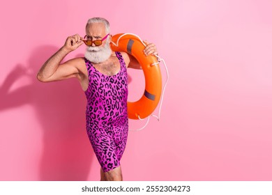 Photo of old man hold touch orange life buoy look sunglass wear swim suit isolated pink color background - Powered by Shutterstock