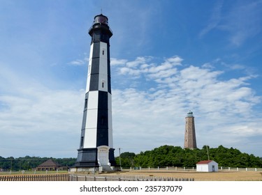 A photo of Old and New Cape Henry Lighthouses in Virginia Beach with birds flying around New Cape Henry lighthouse