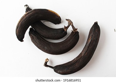 Photo Of An Old Spoiled Banana On A White Background. Black Rotten Banana Peel.