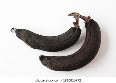 Photo Of An Old Spoiled Banana On A White Background. Black Rotten Banana Peel.