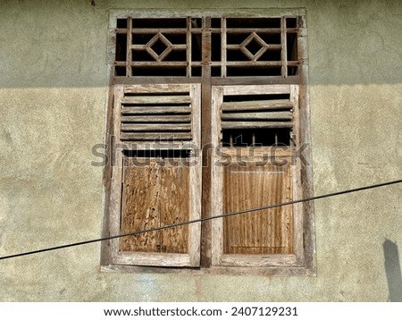 photo of an old window that is slowly rotting and unpainted