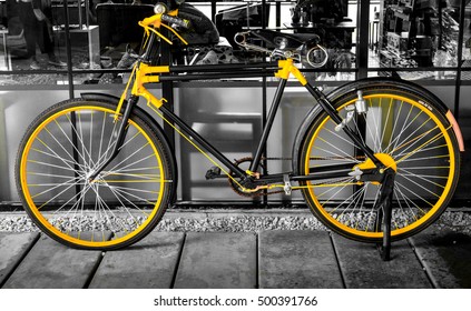photo of old yellow bike on the window of the coffee shop