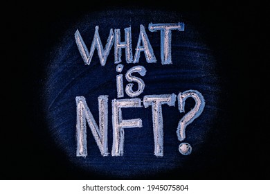 Photo on NFT (non-fungible token) theme. The question "What is NFT?", in the center of the light circle, is drawn with crayons on a chalk board