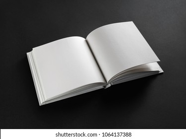 Photo Of Opened Blank Square Book On Black Paper Background.