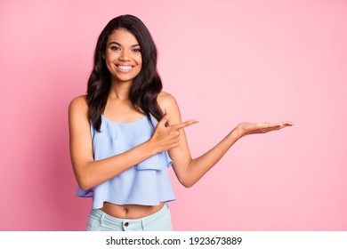 Photo of optimistic brunette lady hold point empty space wear blue top isolated on pink color background - Powered by Shutterstock