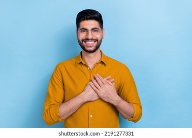 Photo of optimistic carefree dreamy guy in glasses put hands on chest feel grateful thankful charity isolated on blue color background - Shutterstock ID 2191277331