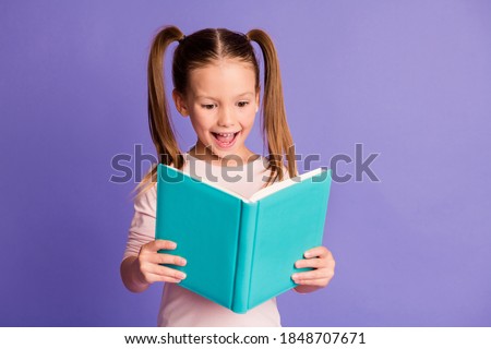 Photo of optimistic happy little girl hold read book study wear pullover isolated on violet color background