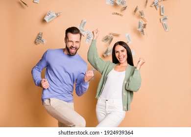 Photo Of Optimistic Nice Couple Win Money Wear Sweater Pants Isolated On Beige Color Background