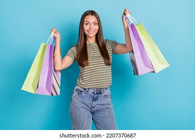 Photo Of Optimistic Satisfied Pretty Girl With Long Hairstyle Wear Striped T-shirt Hold Bags With New Outfit Isolated On Blue Color Background