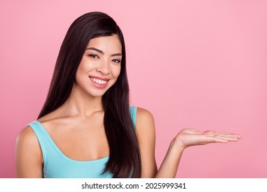 Photo of optimistic young brown hairdo lady hold empty space wear blue top isolated on pastel pink color background - Powered by Shutterstock