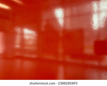 photo of orange glossy wall with a blurry reflective shiny effect that give a creative atmosphere