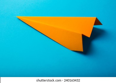 Photo Of Orange Origami Paper Airplane On Blue Paper Background