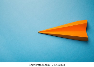 Photo Of Orange Origami Paper Airplane On Blue Paper Background