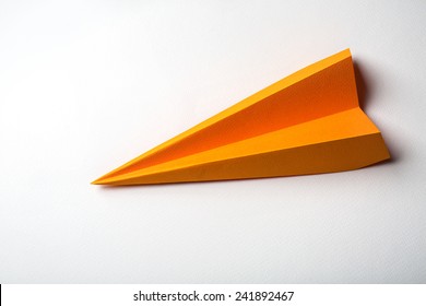 Photo Of Orange Origami Paper Airplane On White Paper Background