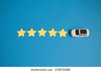 Photo Of An Overhead View Of A Car And Five Stars And A Blue Background