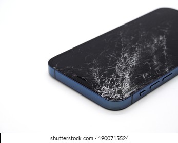 Photo of pacific blue Apple iPhone 12 Pro with broken damaged display. Modern smartphone with damaged glass screen on white background. Device needs repair.