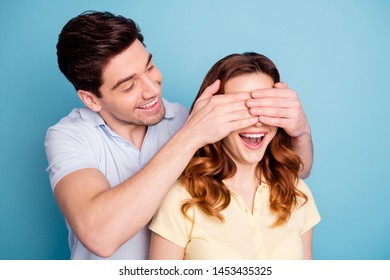 Photo of pair excited bonding romance moment hide eyes do not look guess who wear casual t-shirts isolated blue background