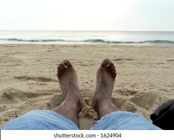 photo of a pair of feet lounging in the sand at VA Beach