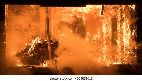 Photo Of Part Of A House On Fire. Window View To Fire Inside Wooden Old House