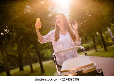 Photo Of Peaceful Lady Hold Telephone Hand Wave Hello Greetings Walk Baby Stroller Outdoors