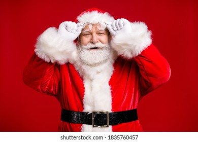 Photo of pensioner old man grey beard take off hold specs smile find taxi discount christmas, eve wear santa costume belt gloves coat spectacles headwear isolated red color background