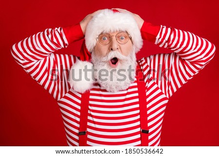 Photo of pensioner old man surprised open mouth hands head good news deer online shop sale wear santa costume suspenders spectacles striped shirt headwear isolated red color background