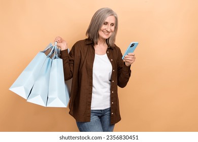 Photo of pensioner woman browsing online store bargains best proposition order online packages shopping isolated on beige color background