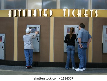 A Photo Of People Buying Movie Tickets At An Automated Machine