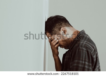 photo of person leaning his head against a wall, worried, stressed, with many problems, pensive, resigned, frustrated. Concept of lifestyles, problems, societal problems.