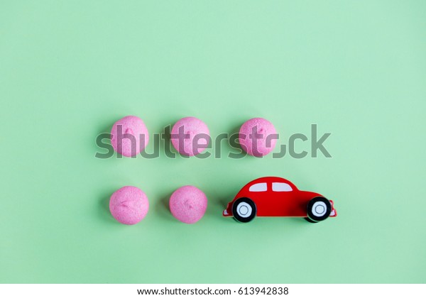 photo of pink marshmallows and car shaped toy\
on the wonderful green\
background