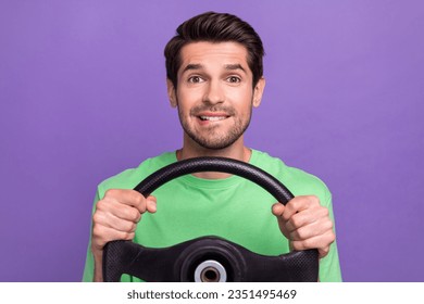 Photo of pleasant impressed man dressed green t-shirt hand on chin biting lip hold steering wheel isolated on purple color background - Powered by Shutterstock