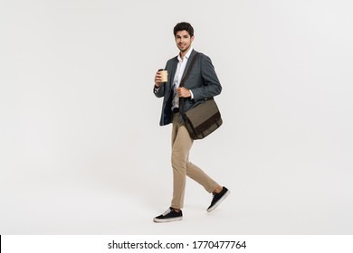 Photo Of Pleased Caucasian Businessman Drinking Coffee While Walking With Bag Isolated Over White Wall