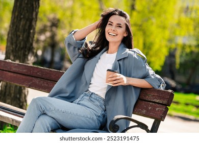 Photo portrait of adorable brunette hair young woman enjoying fresh air in trench and stylish jeans spend fall season outdoors beautiful green park - Powered by Shutterstock