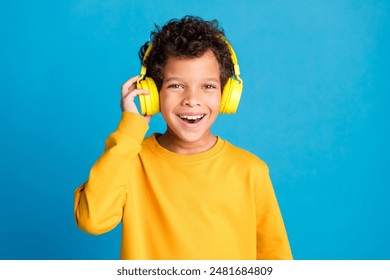 Photo portrait of adorable little boy earphones listen music dressed stylish yellow garment isolated on blue color background - Powered by Shutterstock