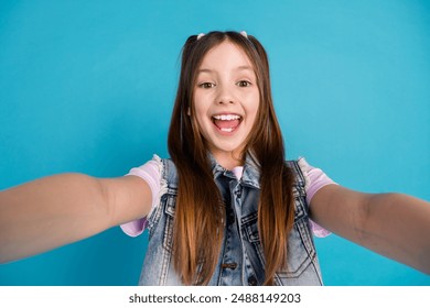 Photo portrait of adorable small girl take selfie photo thumb up excited dressed stylish denim garment isolated on blue color background - Powered by Shutterstock