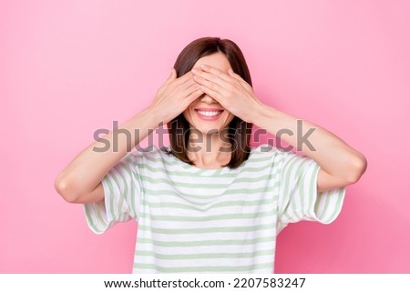 Photo portrait of adorable young lady palms cover eyes smile wait surprise wear trendy striped outfit isolated on pink color background