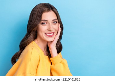 Photo Portrait Of Adorable Young Woman Touch Cheek Perfect Skin Product Promo Dressed Stylish Yellow Look Isolated On Blue Color Background