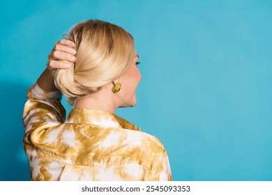 Photo portrait of attractive mature woman hold hair look empty space dressed stylish formalwear clothes isolated on cyan color background - Powered by Shutterstock